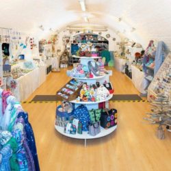 Inside of the shop, featuring a colourful array of products on sale under the arched roof. 